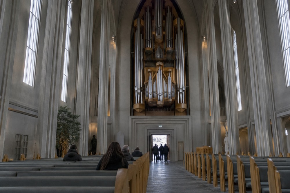 Interior of Hallgrímskirkja with tall narrow nave, stone floor and the large organ above the entrance