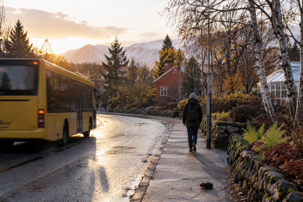 City bus at a stop with a residential street behind it