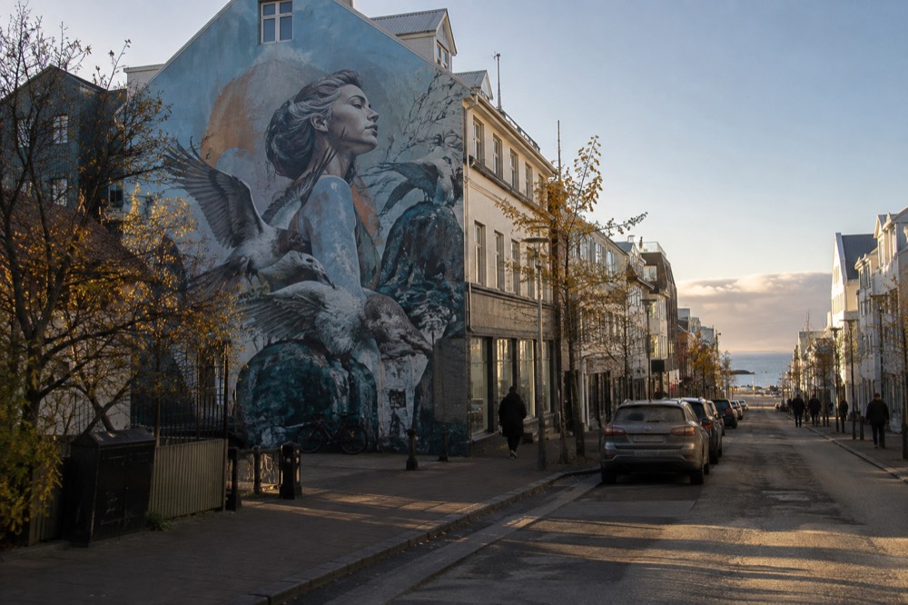 A wide view of a painted mural covering the entire side of a tall building in downtown Reykjavik